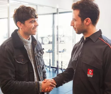 A customer and a mechanic shaking hands